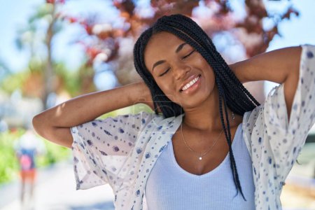 Téléchargez les photos : African american woman smiling confident relaxed with hands on head at park - en image libre de droit