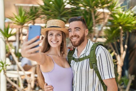 Foto de Hombre y mujer turista pareja sonriendo confiado hacer selfie por teléfono inteligente en la calle - Imagen libre de derechos