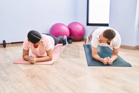 Photo for Man and woman couple smiling confident training abs exercise at sport center - Royalty Free Image