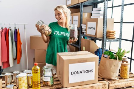 Photo for Young blonde volunteer girl smiling happy standing at charity center. - Royalty Free Image