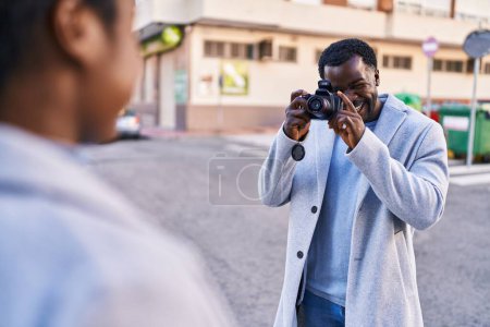 Téléchargez les photos : Homme et femme couple faire des photos en utilisant un appareil photo professionnel à la rue - en image libre de droit