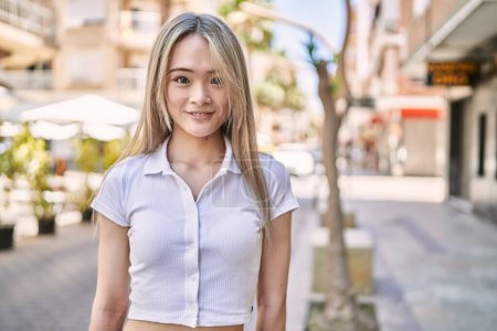 Téléchargez les photos : Jeune fille chinoise souriant heureux debout à la ville. - en image libre de droit