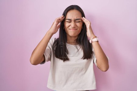 Photo for Young hispanic woman standing over pink background with hand on head, headache because stress. suffering migraine. - Royalty Free Image