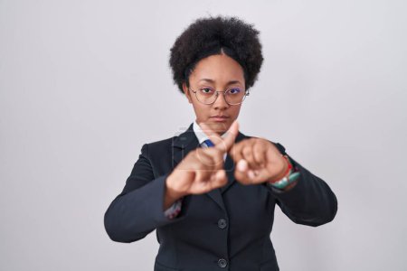 Photo for Beautiful african woman with curly hair wearing business jacket and glasses rejection expression crossing fingers doing negative sign - Royalty Free Image