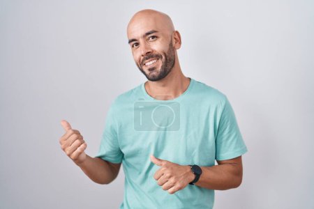 Photo for Middle age bald man standing over white background pointing to the back behind with hand and thumbs up, smiling confident - Royalty Free Image