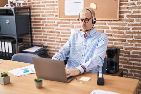 Photo for Young caucasian man wearing call center agent headset scared and amazed with open mouth for surprise, disbelief face - Royalty Free Image