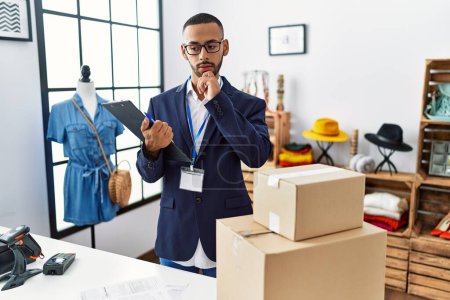 Photo for African american man working as manager at retail boutique with hand on chin thinking about question, pensive expression. smiling with thoughtful face. doubt concept. - Royalty Free Image
