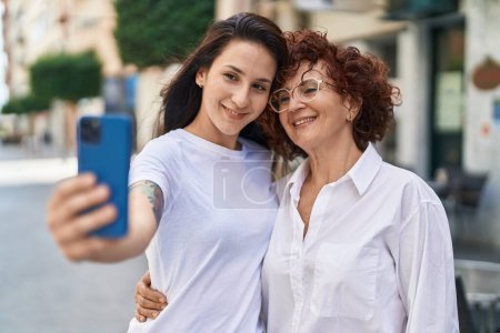 Foto de Dos mujeres madre e hija haciendo selfie por teléfono inteligente en la calle - Imagen libre de derechos