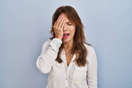Téléchargez les photos : Hispanic woman standing over isolated background yawning tired covering half face, eye and mouth with hand. face hurts in pain. - en image libre de droit