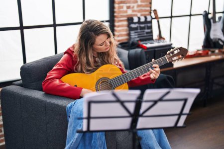 Téléchargez les photos : Young woman musician playing classical guitar at music studio - en image libre de droit
