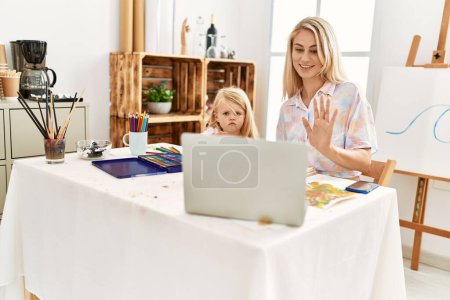 Téléchargez les photos : Mother and daughter smiling confident having video call drawing at art studio - en image libre de droit