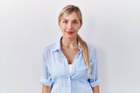 Photo for Beautiful blonde woman standing over white background relaxed with serious expression on face. simple and natural looking at the camera. - Royalty Free Image