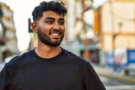 Téléchargez les photos : Jeune homme arabe souriant confiant à la rue - en image libre de droit
