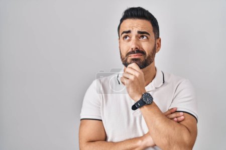 Photo for Young hispanic man with beard wearing casual clothes over white background thinking worried about a question, concerned and nervous with hand on chin - Royalty Free Image