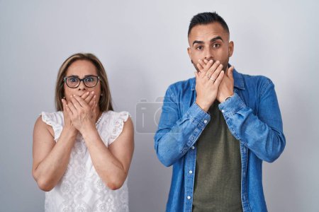 Téléchargez les photos : Hispanic mother and son standing together shocked covering mouth with hands for mistake. secret concept. - en image libre de droit