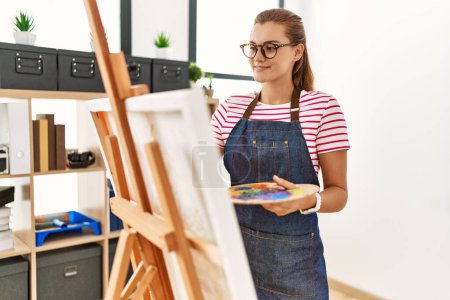 Téléchargez les photos : Jeune femme souriant dessin confiant au studio d'art - en image libre de droit