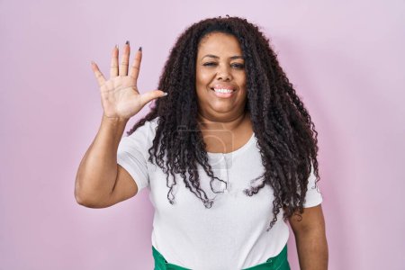 Téléchargez les photos : Plus taille hispanique femme debout sur fond rose montrant et pointant vers le haut avec les doigts numéro cinq tout en souriant confiant et heureux. - en image libre de droit
