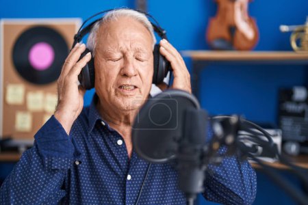Photo for Senior grey-haired man artist singing song at music studio - Royalty Free Image