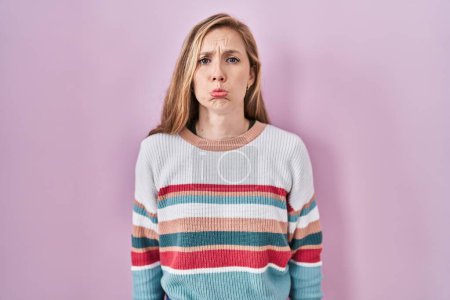 Photo for Young blonde woman standing over pink background depressed and worry for distress, crying angry and afraid. sad expression. - Royalty Free Image