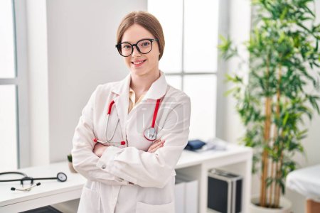 Photo for Young blonde woman wearing doctor uniform standing with arms crossed gesture at clinic - Royalty Free Image