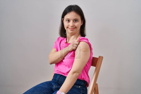 Téléchargez les photos : Femme atteinte du syndrome du duvet portant un pansement pour injection de vaccin ayant l'air positive et heureuse debout et souriante avec un sourire confiant montrant les dents - en image libre de droit