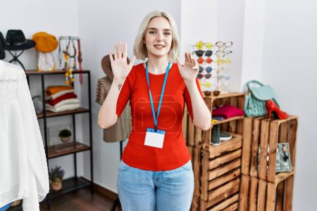 Téléchargez les photos : Jeune femme caucasienne travaillant comme gestionnaire à la boutique de détail montrant et pointant vers le haut avec les doigts numéro neuf tout en souriant confiant et heureux. - en image libre de droit