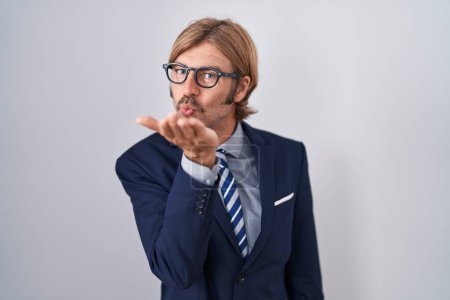 Photo for Caucasian man with mustache wearing business clothes looking at the camera blowing a kiss with hand on air being lovely and sexy. love expression. - Royalty Free Image