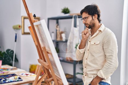 Photo for Young hispanic man artist drawing with serious expression at art studio - Royalty Free Image
