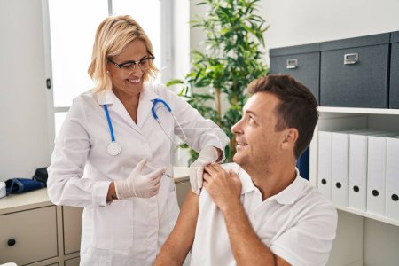 Photo for Middle age man and woman doctor and patient vaccinating at clinic - Royalty Free Image