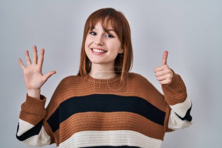 Foto de Young beautiful woman wearing striped sweater over isolated background showing and pointing up with fingers number six while smiling confident and happy. - Imagen libre de derechos
