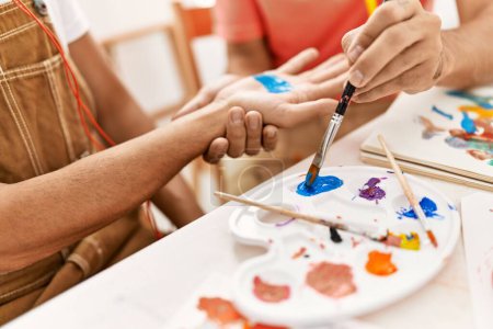 Photo for Two hispanic men couple painting palm hands at art studio - Royalty Free Image
