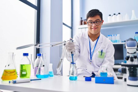 Photo for Down syndrome man wearing scientist uniform measuring liquid at laboratory - Royalty Free Image