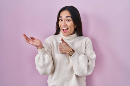 Photo for Young south asian woman standing over pink background showing palm hand and doing ok gesture with thumbs up, smiling happy and cheerful - Royalty Free Image