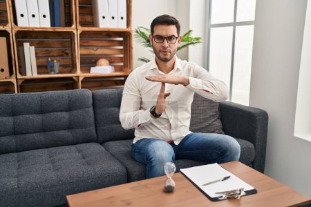 Téléchargez les photos : Jeune homme hispanique avec barbe travaillant au bureau de consultation faisant un geste avec les mains, frustré et sérieux visage - en image libre de droit