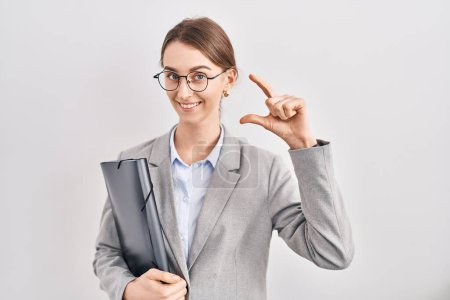 Photo for Young caucasian woman wearing business clothes and glasses smiling and confident gesturing with hand doing small size sign with fingers looking and the camera. measure concept. - Royalty Free Image