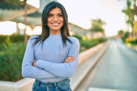 Photo for Beautiful hispanic woman smiling confient with crossed arms at the city - Royalty Free Image