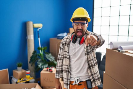 Photo for Young hispanic man with beard working at home renovation pointing displeased and frustrated to the camera, angry and furious with you - Royalty Free Image