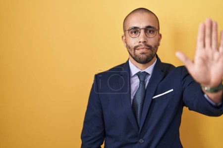 Photo for Hispanic man with beard wearing suit and tie doing stop sing with palm of the hand. warning expression with negative and serious gesture on the face. - Royalty Free Image