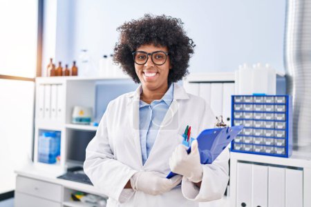 Photo for African american woman scientist smiling confident holding clipboard at laboratory - Royalty Free Image