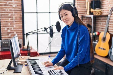 Photo for Chinese woman musician composing song at music studio - Royalty Free Image