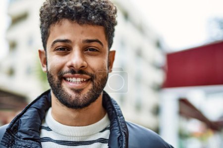 Téléchargez les photos : Jeune homme arabe souriant en plein air à la ville - en image libre de droit