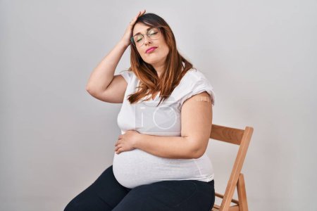 Photo for Pregnant woman wearing band aid for vaccine injection stressed and frustrated with hand on head, surprised and angry face - Royalty Free Image