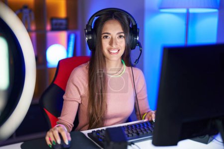 Téléchargez les photos : Jeune femme hispanique jouant à des jeux vidéo avec un sourire heureux et cool sur le visage. chanceux. - en image libre de droit