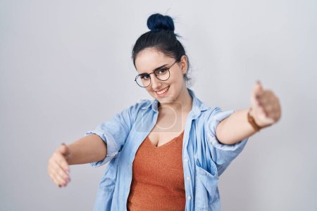 Téléchargez les photos : Young modern girl with blue hair standing over white background looking at the camera smiling with open arms for hug. cheerful expression embracing happiness. - en image libre de droit