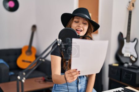 Téléchargez les photos : Jeune belle musicienne hispanique chantant au studio de musique - en image libre de droit