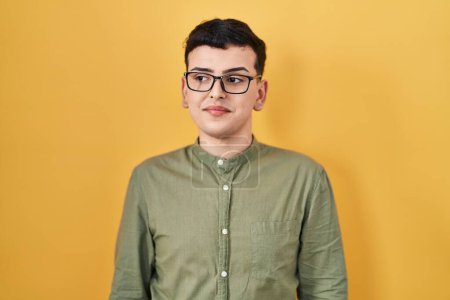 Téléchargez les photos : Non binary person standing over yellow background smiling looking to the side and staring away thinking. - en image libre de droit