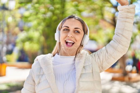Photo for Young woman smiling confident listening to music at park - Royalty Free Image