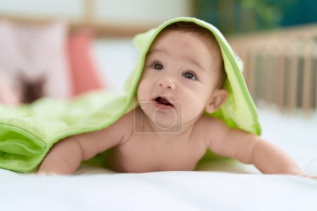 Photo for Adorable toddler lying on bed covering with funny towel at bedroom - Royalty Free Image