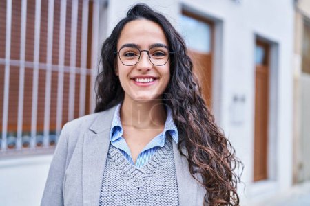 Téléchargez les photos : Young hispanic woman executive smiling confident at street - en image libre de droit