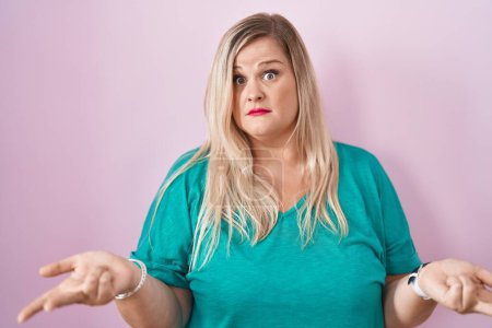 Photo for Caucasian plus size woman standing over pink background clueless and confused with open arms, no idea concept. - Royalty Free Image
